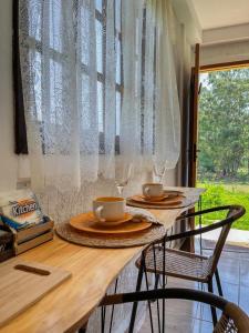 einen Tisch mit zwei Stühlen und zwei Tassen darauf in der Unterkunft Chalé Quinta São Miguel 01 - Econômico in Santo Antônio do Pinhal