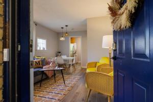 a living room with a blue door and a yellow couch at Stylish Stay in the Heart of Decatur King Bed in Decatur