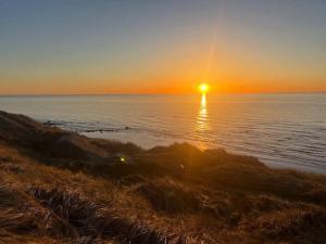 a sunset over the ocean with the sun in the sky at 6 person holiday home in Hirtshals in Hirtshals
