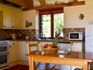 Saint EndellionにあるRound House - Uk12083のキッチン(テーブル、フルーツバスケット付)