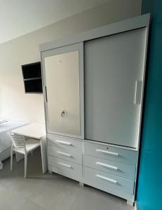 a large dresser with a table and a bed at 4 quartos Conforto e silêncio no coração de BH in Belo Horizonte