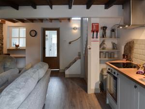 un salon avec un canapé et une cuisine dans l'établissement Ty Bobbet, à Amlwch