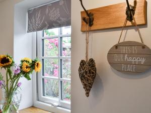 une fenêtre avec un panneau indiquant que c'est notre endroit heureux dans l'établissement Ty Bobbet, à Amlwch