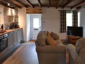 un salon avec deux canapés et une cuisine dans l'établissement Ty Bobbet, à Amlwch