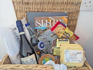 a basket filled with food and a bottle of wine at Shepherds Hut - Ukc6774 in Llanallgo