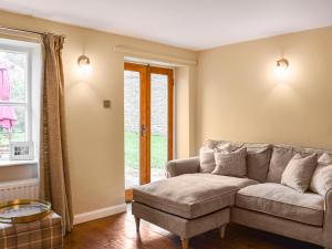 a living room with a couch and a window at Uk45895 - Cross House Cottage in Kirkby Lonsdale