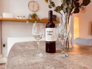 ニュービギン・バイ・ザ・シーにあるRothsay Beach Houseのワイン1本とワイングラス2杯(テーブル上)