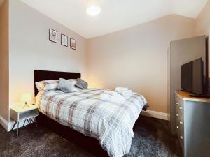 ニュービギン・バイ・ザ・シーにあるRothsay Beach Houseのベッドと薄型テレビのある寝室 +11枚の写真