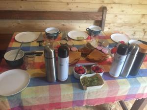 a table with plates and food on a colorful table cloth at cabane féérique in Pléneuf-Val-André