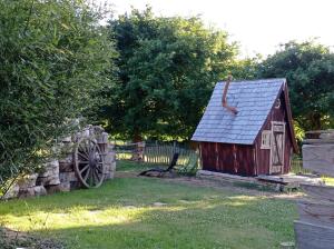 un fienile rosso con tetto in ardesia accanto a una recinzione di cabane féérique a Pléneuf-Val-André