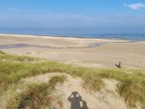 a shadow of a person walking on a beach at 6 person holiday home in Fjerritslev in Fjerritslev