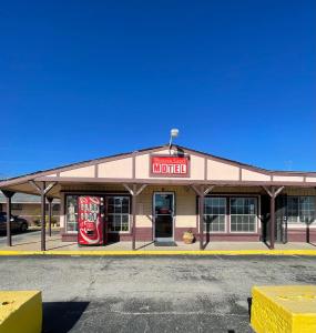 Un edificio con un cartel de Coca Cola. en Western Capri Motel, en Tulsa