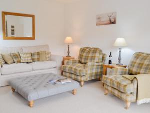 ein Wohnzimmer mit einer Couch und zwei Sesseln in der Unterkunft Boatman's Cottage At Invernian Mor in Inverinan Beg