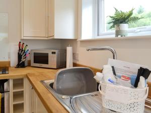 eine Küchenspüle mit einem Wäscheständer in der Unterkunft Boatman's Cottage At Invernian Mor in Inverinan Beg