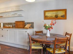 eine Küche mit einem Tisch mit einer Blumenvase in der Unterkunft Duke Of Wellington Hq in Hastings
