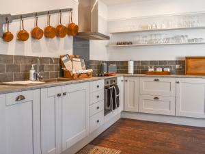 eine Küche mit weißen Schränken und Holzböden in der Unterkunft Duke Of Wellington Hq in Hastings
