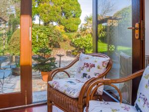 une chaise en osier assise sur un porche à côté d'une porte vitrée dans l'établissement Frankaborough Cottage - Uk48326, à Lifton