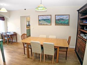 a dining room with a wooden table and chairs at Aira Cottage in Watermillock