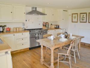 een keuken met een houten tafel en een fornuis bij The Linhay in Westleigh