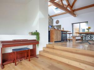 a living room with a piano and a table at Vredehoek in Quethiock