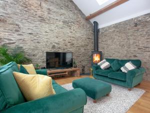 a living room with two green couches and a tv at Vredehoek in Quethiock
