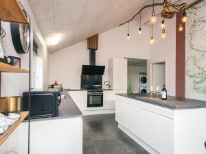 a kitchen with white cabinets and a stove top oven at 14 person holiday home in Glesborg in Glesborg +31 photos