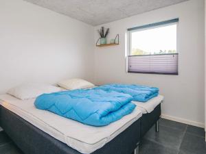 a bed with a blue comforter in a room at 14 person holiday home in Glesborg in Glesborg