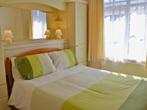 a bedroom with a bed with white and green pillows at Hope Cottage in Lindale