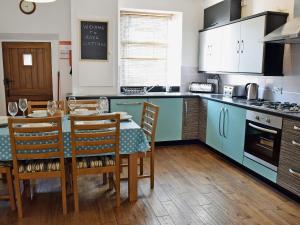 a kitchen with a table and chairs in a kitchen at Rose Cottage in Low Bradley