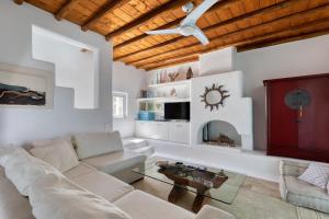 a living room with a white couch and a table at Villa Zanetti Mykonos in Agios Ioannis Mykonos