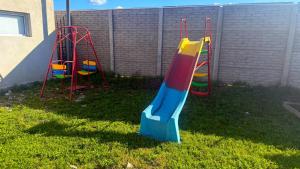 two playground equipment in the grass in a yard at Departamento por dia in Pehuajo +28 photos