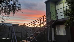 a staircase leading to a building with a sunset in the background at Rada Tilly Apart 2 Unidad 6 in Rada Tilly