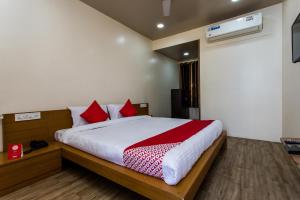 a bedroom with a large bed with red pillows at Hotel O Riddhi Siddhi in Indore
