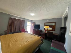 una habitación de hotel con una cama y un escritorio en Western Capri Motel, en Tulsa 2 fotos más