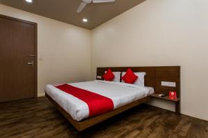 a bedroom with a large bed with red pillows at Hotel O Riddhi Siddhi in Indore