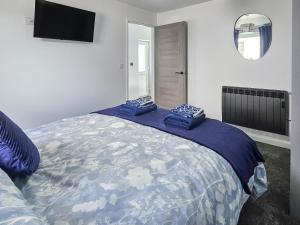 une chambre avec un grand lit avec une couette bleue dans l'établissement Llaethdy Arfryn, à Maenclochog 10 autres photos