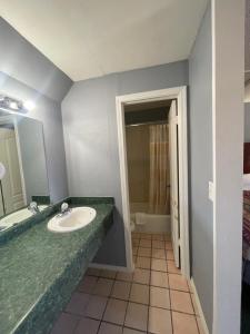 un baño con lavabo y espejo en Western Capri Motel, en Tulsa