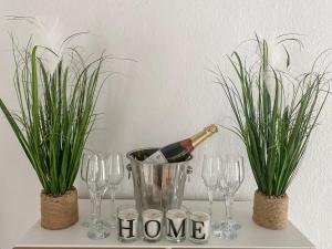 une bouteille de vin dans un seau avec des verres et des plantes dans l'établissement Holly Cottage, à Palnackie