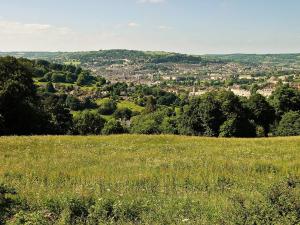 a field of grass with a town in the distance at Eastwood Lodge in Bath