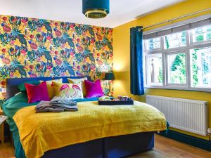 ein Schlafzimmer mit einem Bett mit gelben Wänden und einer Blumentapete in der Unterkunft The Retreat in Saint Leonards