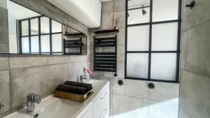 a bathroom with a tub and a sink and windows at Au Petit Vélo - Appart Vue sur la Bâtie - Parking Gratuit & Calme - Vienne in Vienne +29 photos