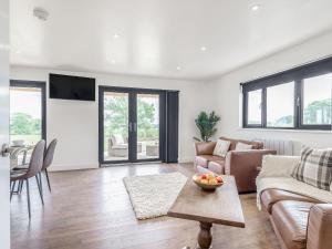 a living room with a couch and a table at Oak Tree Lodge - Uk38383 in Lyonshall
