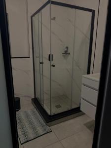 eine Glasdusche im Bad mit Waschbecken in der Unterkunft Waterfall Munyaka Estate in Midrand