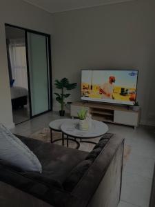 ein Wohnzimmer mit Couch und Flachbildfernseher in der Unterkunft Waterfall Munyaka Estate in Midrand
