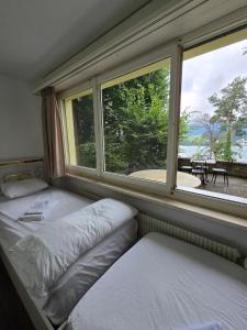 a bedroom with two beds and a large window at Queen Home1 in Lucerne