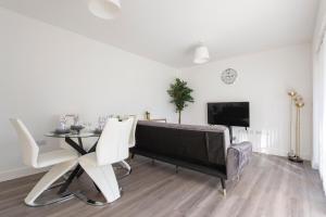 een woonkamer met een piano en een tafel en stoelen bij Casa Di Dolce Two Bedroom Apartment with Balcony in Maidstone