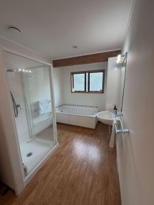 une salle de bain avec une douche, une baignoire et un lavabo dans l'établissement Kiwi Classic, à Red Beach