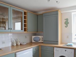 cocina con armarios verdes y microondas en Making Waves, en Anstruther 18 fotos más