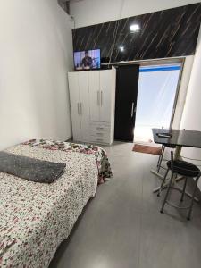 a bedroom with a bed and a table and a tv at Lar Doce Lar Realizando Sono!!! in Arcos