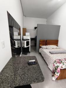 a bedroom with a bed and a remote control on a rug at Lar Doce Lar Realizando Sono!!! in Arcos